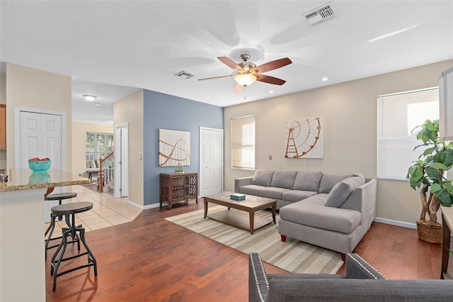 living room with ceiling fan, light hardwood / wood-style flooring, and plenty of natural light