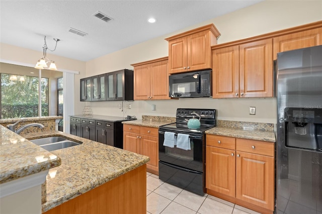 kitchen with sink, black appliances, light tile patterned floors, a chandelier, and light stone counters