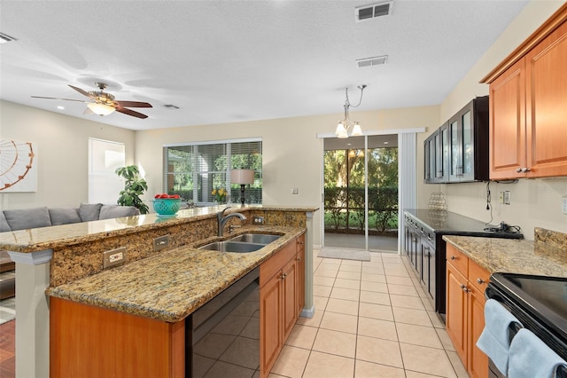 kitchen featuring a healthy amount of sunlight, a textured ceiling, sink, and a kitchen island with sink