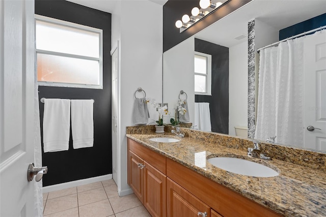 bathroom with vanity, toilet, plenty of natural light, and tile patterned flooring