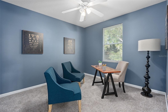 carpeted home office featuring ceiling fan