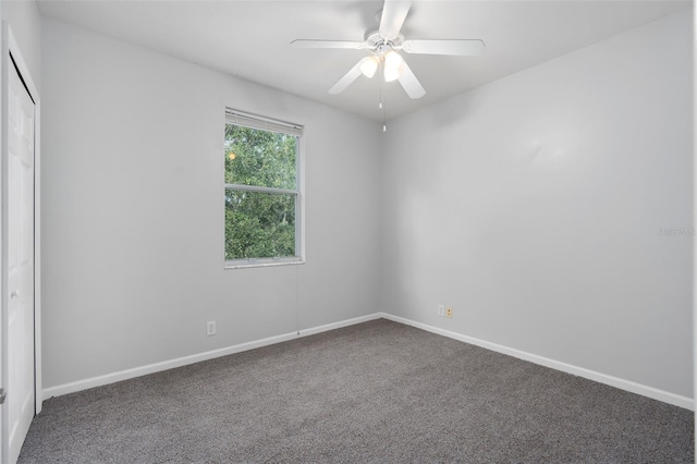 carpeted spare room featuring ceiling fan