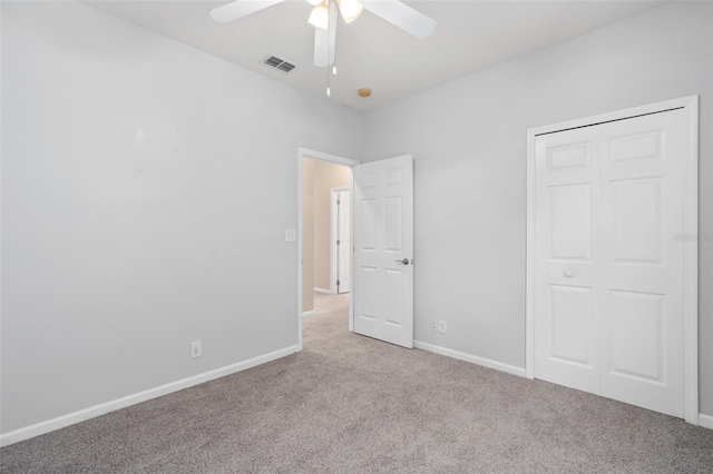 unfurnished bedroom featuring a closet, ceiling fan, and light colored carpet