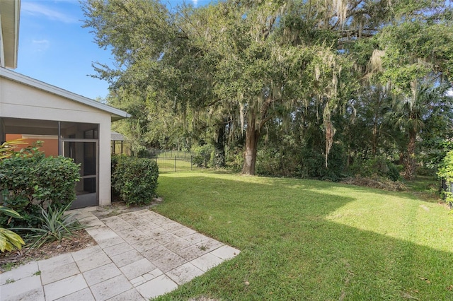 view of yard featuring a sunroom and a patio area