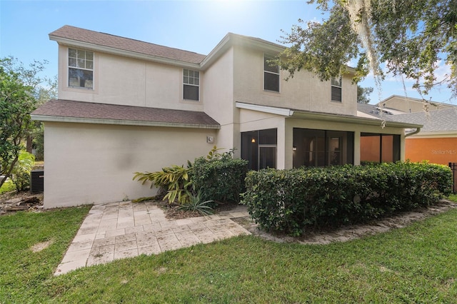 rear view of property with a lawn and a sunroom