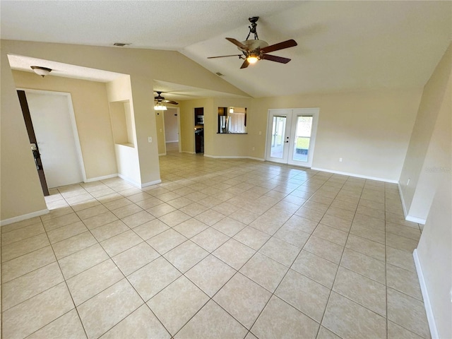 tiled spare room featuring french doors, ceiling fan, and vaulted ceiling