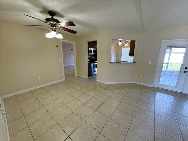 tiled spare room with a textured ceiling and ceiling fan