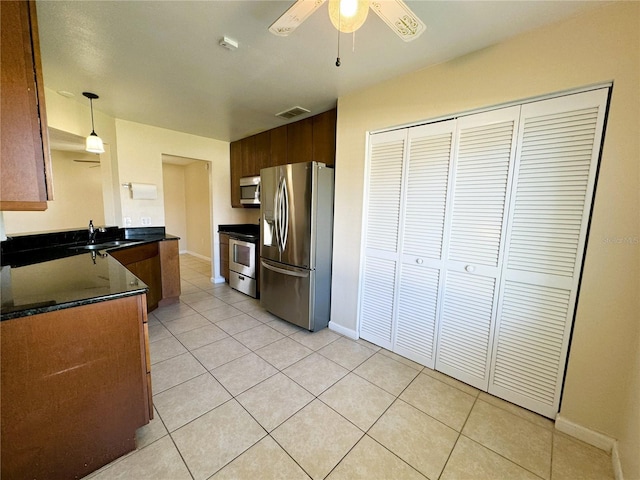 kitchen with appliances with stainless steel finishes, sink, ceiling fan, pendant lighting, and light tile patterned floors