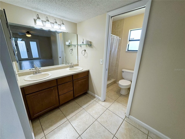 bathroom featuring vanity, toilet, a textured ceiling, and tile patterned flooring