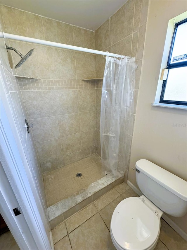 bathroom featuring toilet, walk in shower, and tile patterned floors