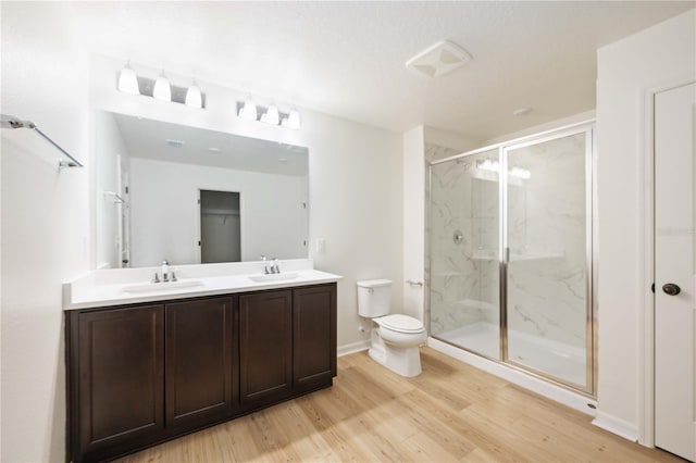 bathroom with vanity, wood-type flooring, a shower with shower door, and toilet