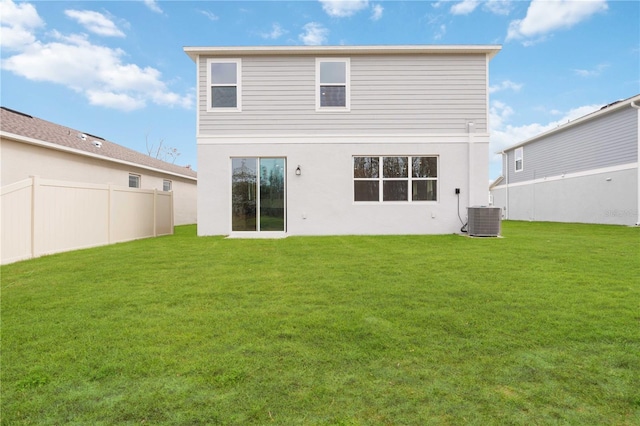 rear view of property with a yard and central AC unit