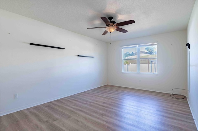 unfurnished room featuring ceiling fan, light hardwood / wood-style flooring, and a textured ceiling