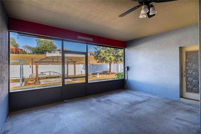 unfurnished sunroom with ceiling fan