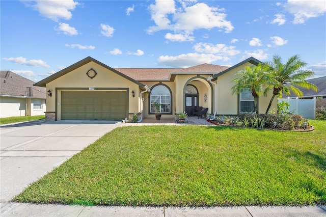 mediterranean / spanish-style home featuring a garage and a front lawn