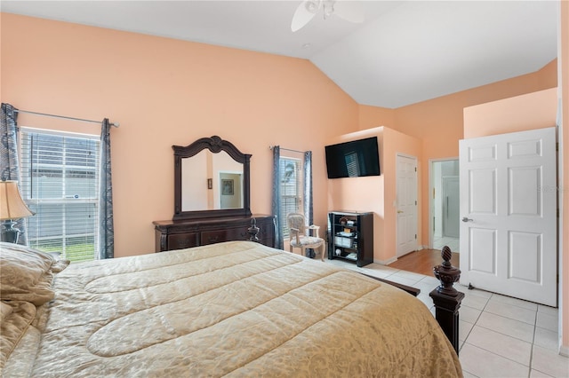 bedroom with ceiling fan, vaulted ceiling, and light tile patterned floors