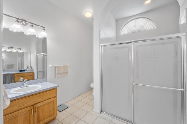 bathroom with vanity, toilet, a shower with shower door, and a wealth of natural light