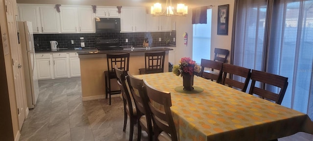 dining area featuring a healthy amount of sunlight and a chandelier