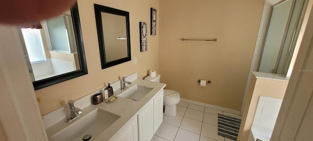 bathroom featuring toilet, vanity, a shower, and tile patterned flooring