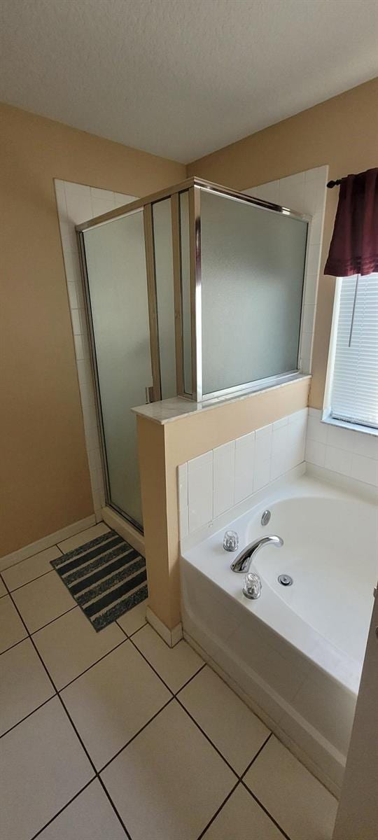 bathroom with tile patterned flooring, a textured ceiling, and separate shower and tub