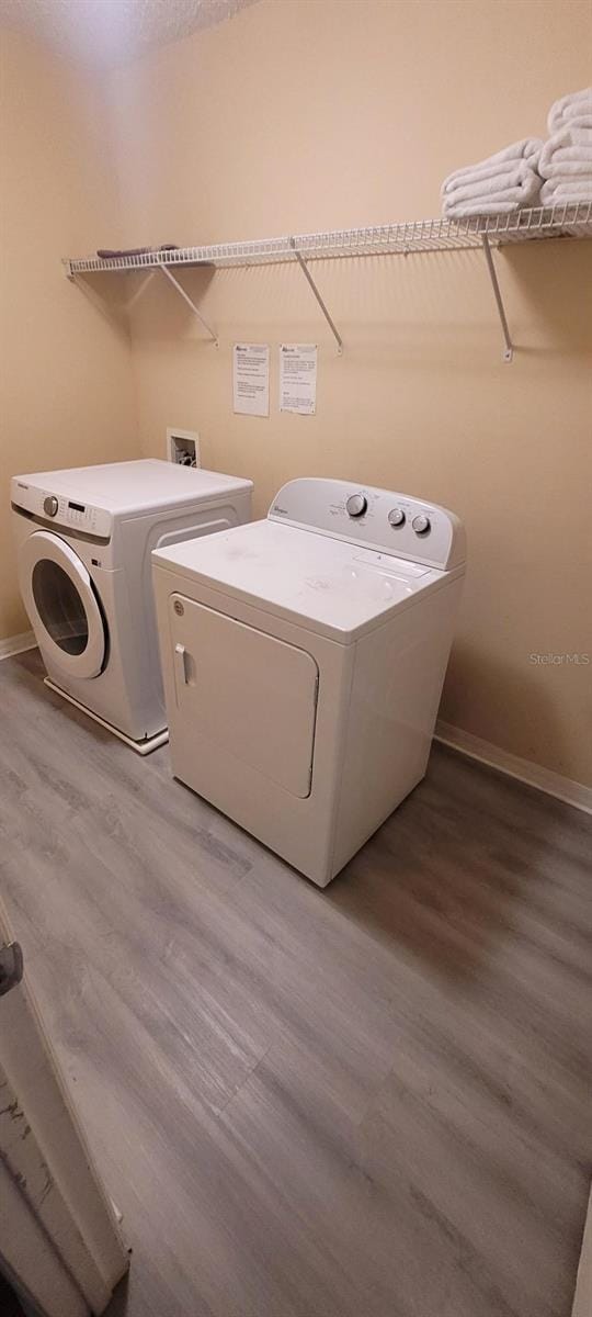 laundry area with hardwood / wood-style floors and washer and dryer