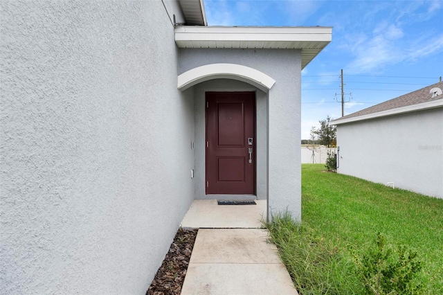 property entrance featuring a lawn