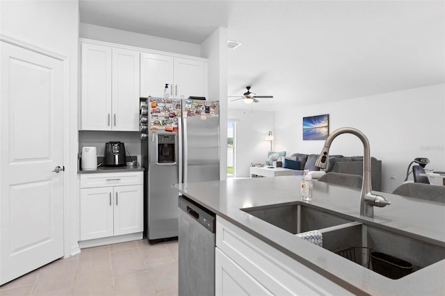 kitchen featuring appliances with stainless steel finishes, white cabinets, sink, and light tile patterned floors