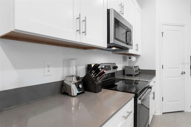 kitchen featuring white cabinetry, appliances with stainless steel finishes, and light tile patterned floors