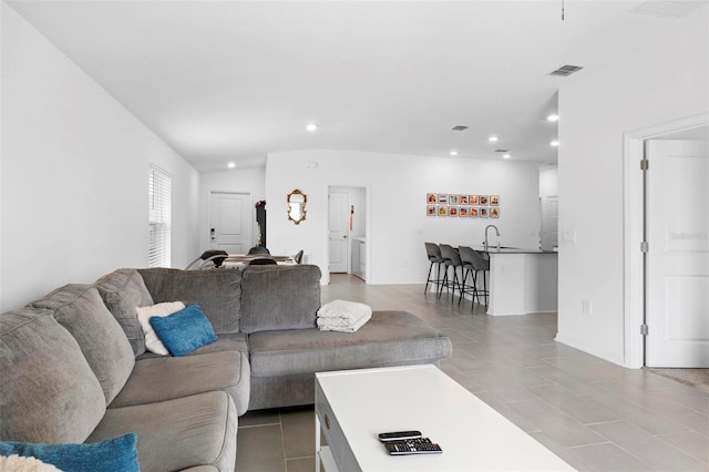 tiled living room featuring sink