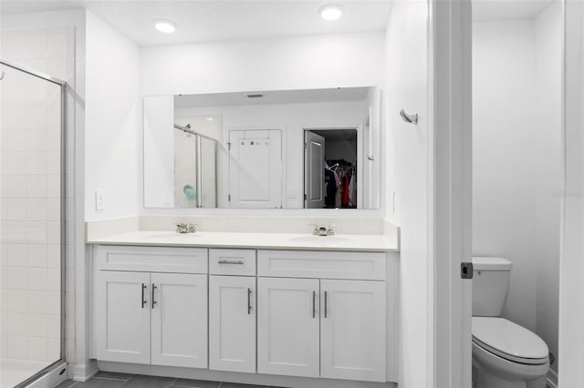 bathroom with toilet, a shower with shower door, vanity, and tile patterned flooring