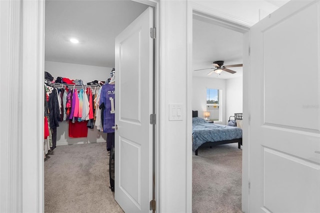 spacious closet featuring light carpet and ceiling fan