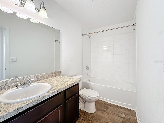 full bathroom featuring toilet, tiled shower / bath, vanity, and wood-type flooring