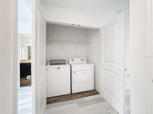 laundry room featuring light hardwood / wood-style floors and washer and dryer