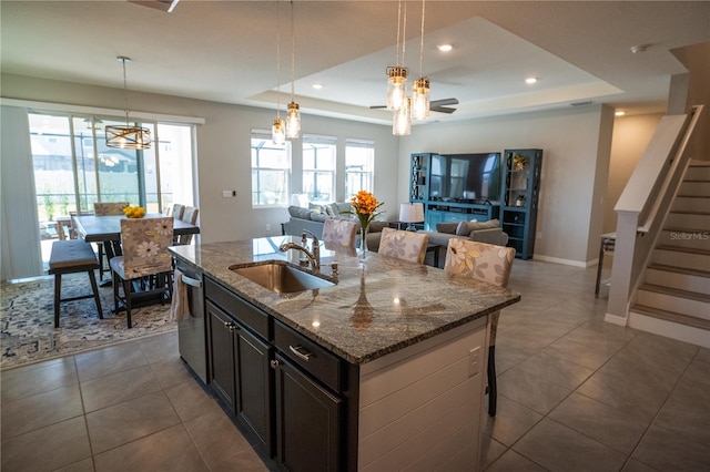 kitchen with open floor plan, an island with sink, a sink, and decorative light fixtures