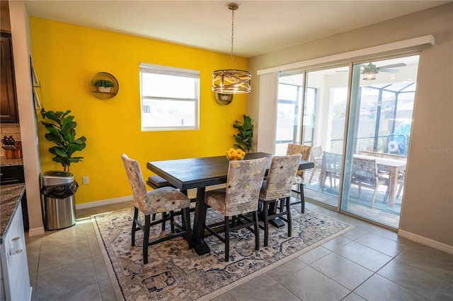 dining room with a wealth of natural light, light tile patterned flooring, and baseboards