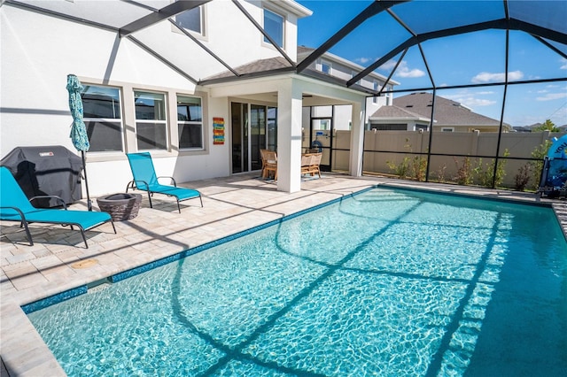 view of pool with glass enclosure, a patio area, fence, and a fenced in pool