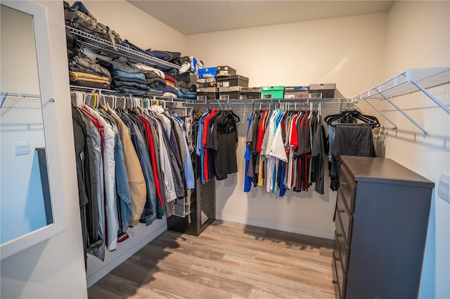 walk in closet with light wood-style flooring