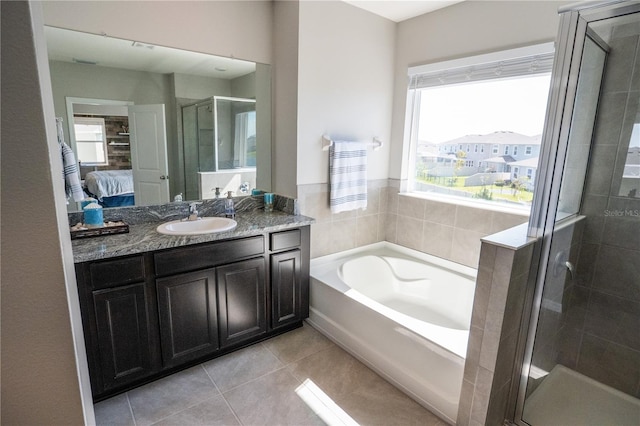 bathroom with a garden tub, ensuite bath, a shower stall, tile patterned flooring, and vanity