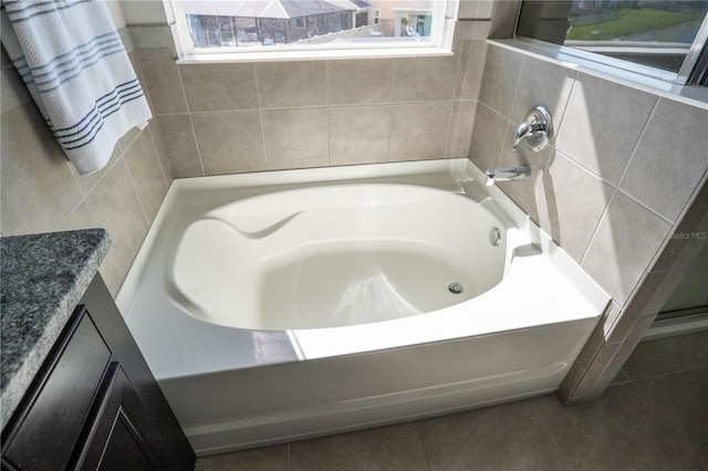 full bath with a garden tub, vanity, and tile patterned floors