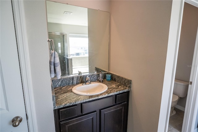 full bathroom with a stall shower, toilet, and vanity