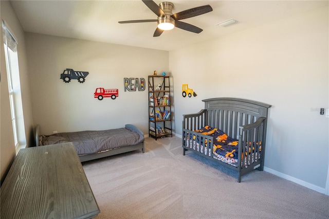 bedroom with a ceiling fan, light colored carpet, visible vents, and baseboards