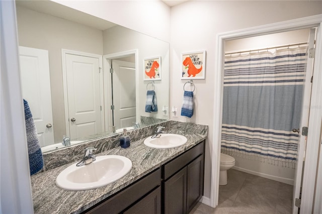 full bath featuring a sink, toilet, double vanity, and tile patterned floors