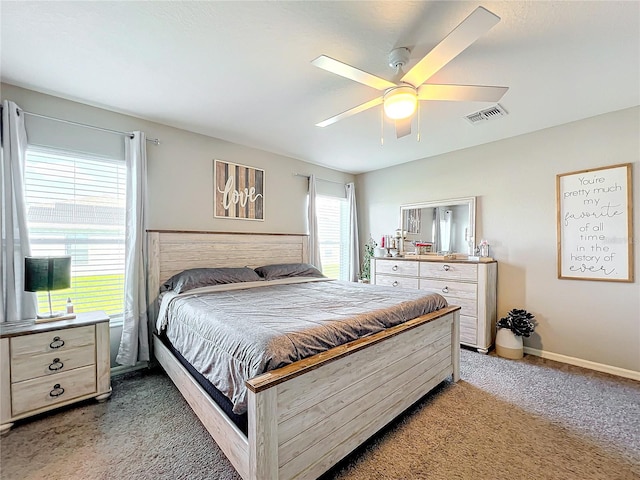 bedroom featuring ceiling fan, multiple windows, and carpet floors