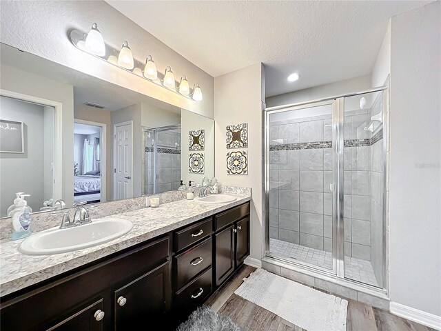 bathroom with vanity, a textured ceiling, hardwood / wood-style flooring, and walk in shower