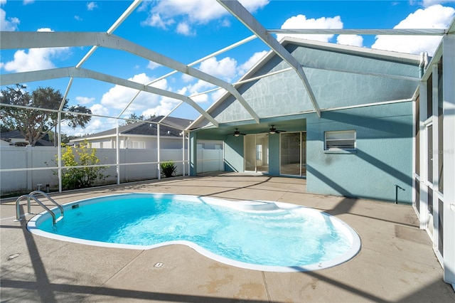 view of swimming pool featuring glass enclosure, ceiling fan, and a patio