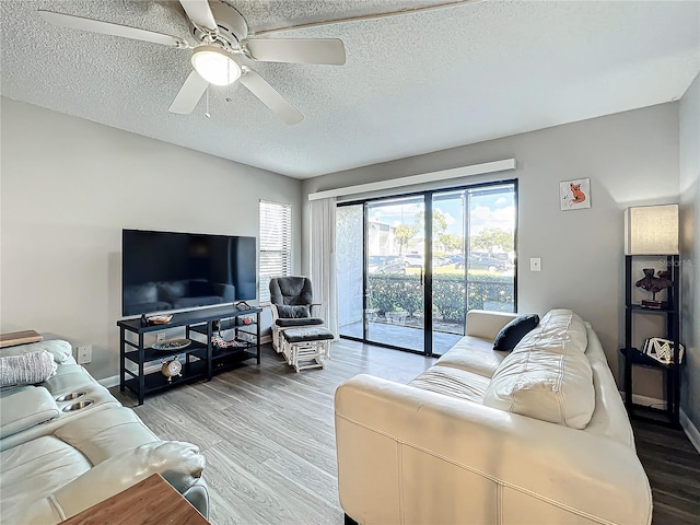 living room with hardwood / wood-style floors, a textured ceiling, and ceiling fan