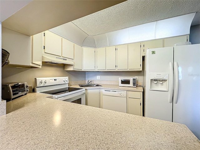 kitchen with sink, a textured ceiling, and white appliances