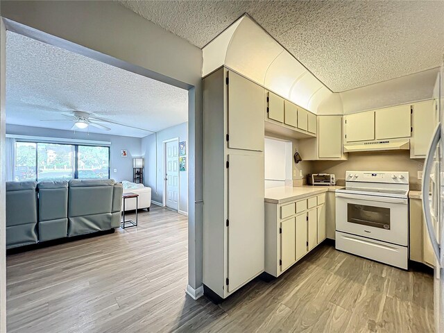 kitchen featuring ceiling fan, white electric range oven, light hardwood / wood-style flooring, and cream cabinetry