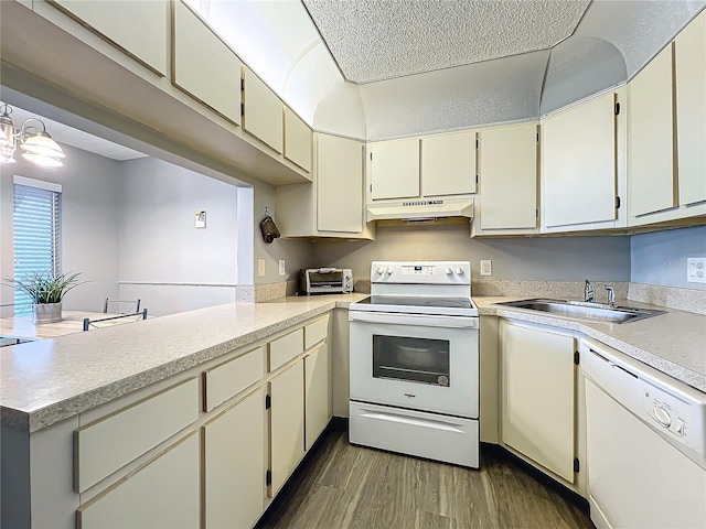 kitchen with white appliances, sink, cream cabinetry, kitchen peninsula, and dark wood-type flooring