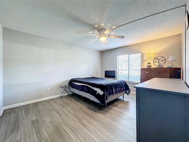 bedroom with a textured ceiling, hardwood / wood-style flooring, and ceiling fan